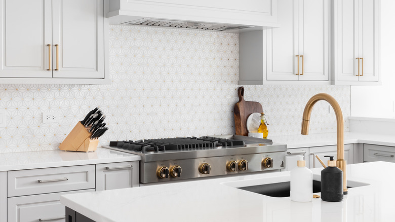 White quartz countertops are installed in a modern and airy kitchen