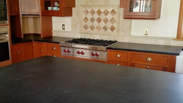 Wooden kitchen cabinets with soapstone countertop island