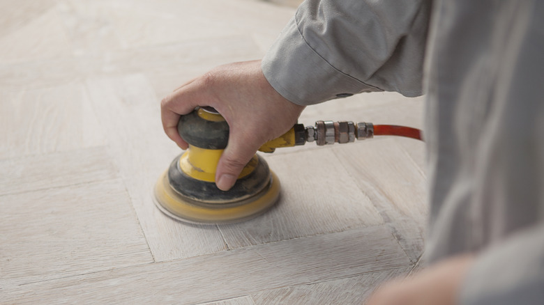 A man sanding floor tiles