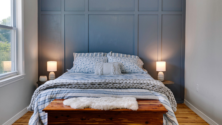 A bedroom with a slate blue accent wall