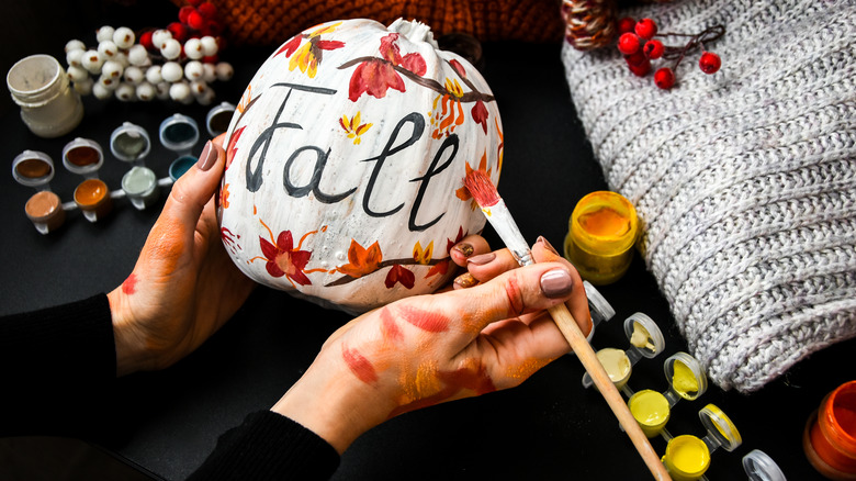 person painting pumpkin