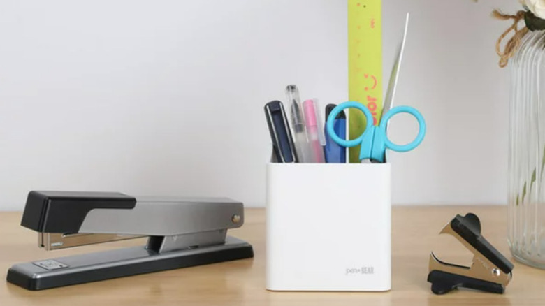 white pen holder with supplies