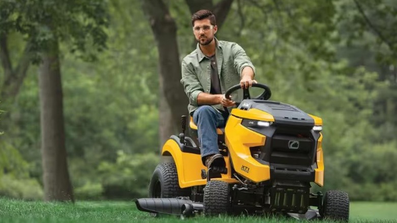 A person driving a Cub Cadet riding mower