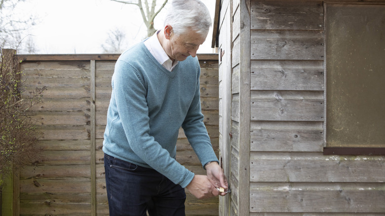 man locking shed