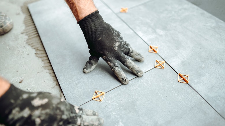 Worker installing ceramic tile