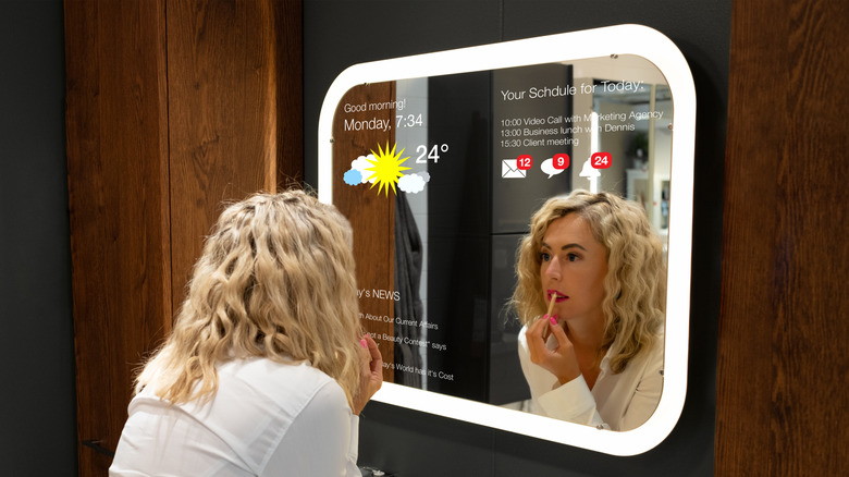 Blond woman applying makeup infront of smart mirror