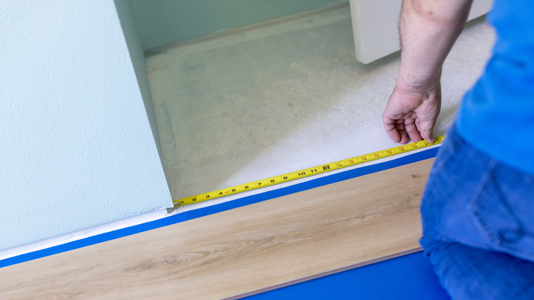 Contractor measuring opening in floor