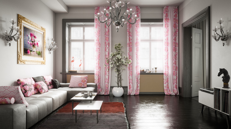 Large living room with gray tones dressed with pink curtains and pink cushions on a gray couch