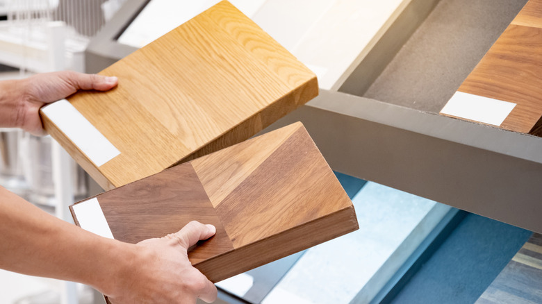 A person's hands holding two blocks of wood.