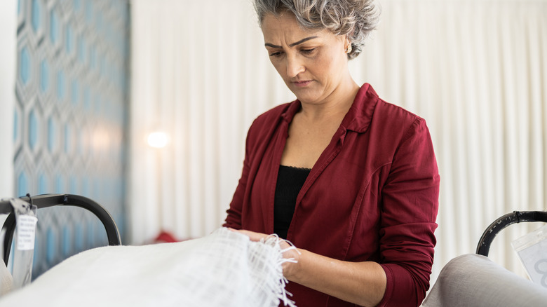 Woman holding fabric and thinking