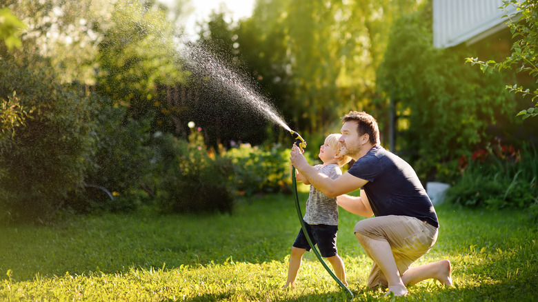 Man and child spraying water