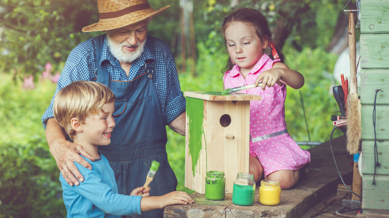 family painting a birdhouse