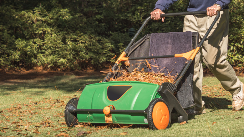 man using a lawn sweeper