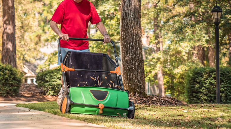 man using a lawn sweeper