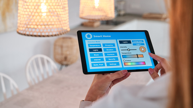 Person adjusting smart home settings on tablet