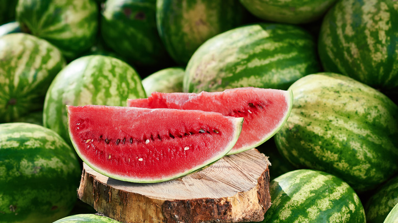 sliced watermelon among whole watermelons