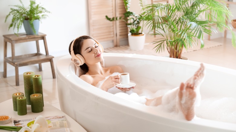 woman enjoying music in bathtub