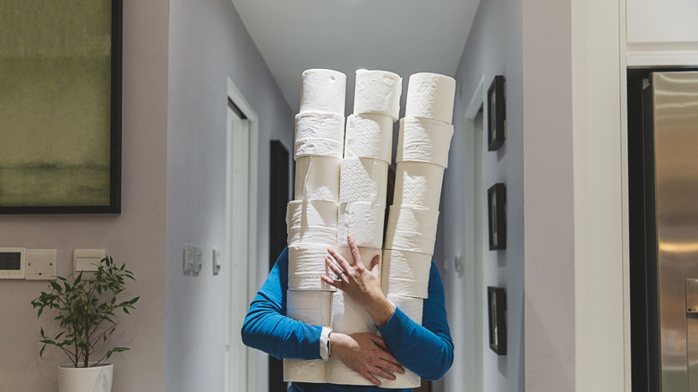 Person carrying extra toilet paper rolls