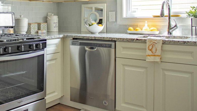 A white kitchen with a stainless steel dishwasher