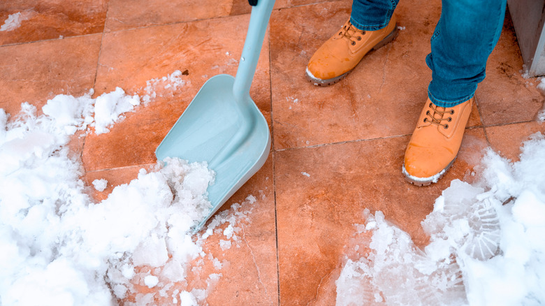 shoveling patio with plastic shovel