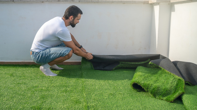 A person installing artificial turf