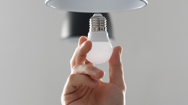hand installing an LED bulb