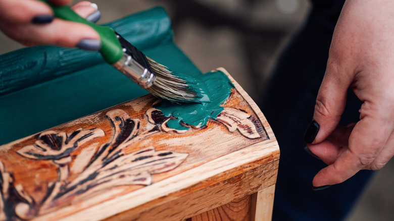 Person painting cabinetry 