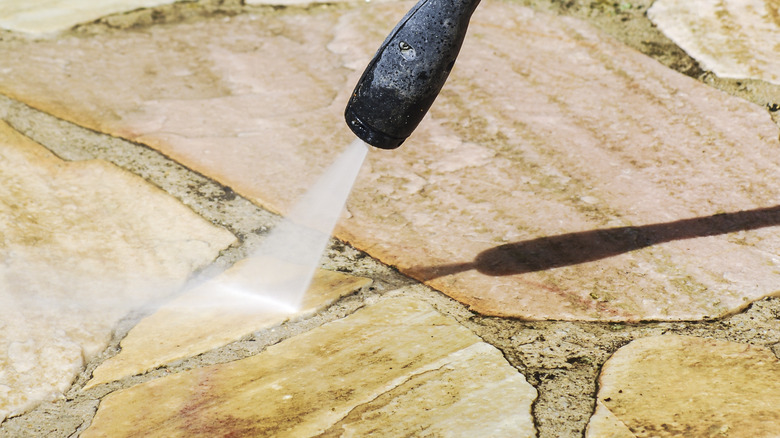 Spraying sealant onto paver stones