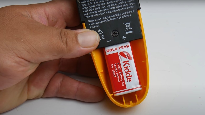 person changing stud finder battery