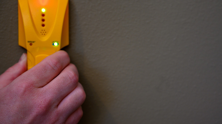 person holding stud finder