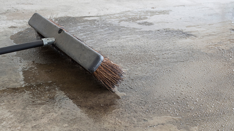 broom scrubbing concrete floor