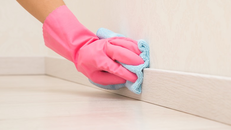 Person cleaning baseboards