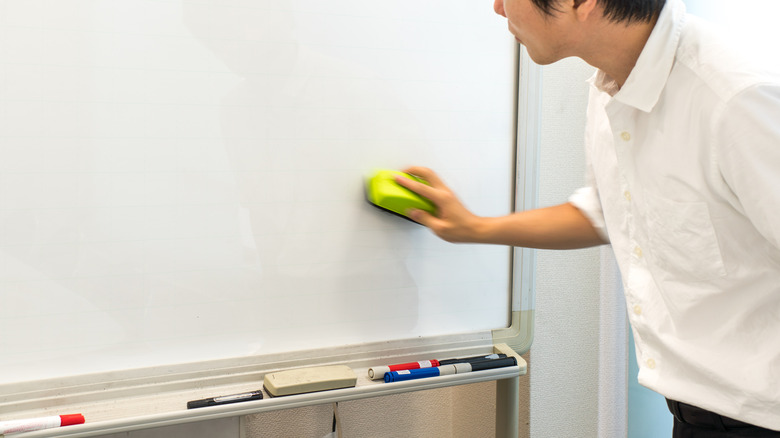 businessman cleaning whiteboard