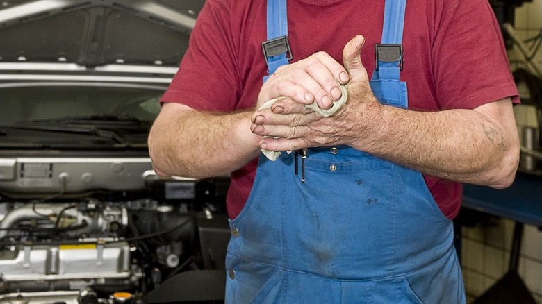 Mechanic wiping oily hands