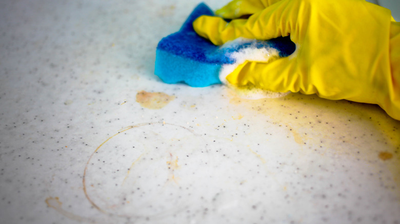 Person cleaning stained countertop