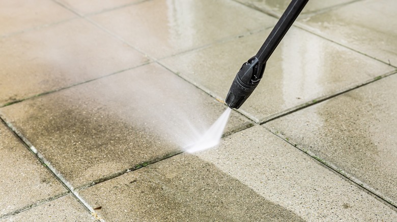 Close up of power washer spraying concrete grout