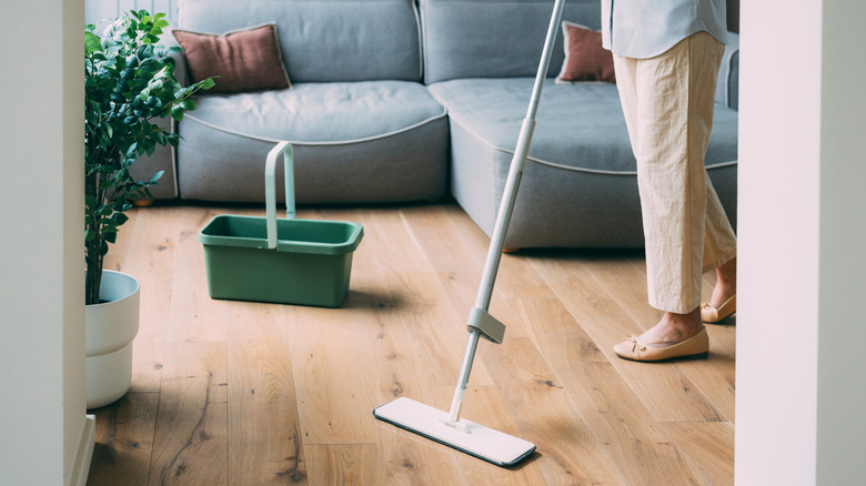 woman mopping wooden floor in living room