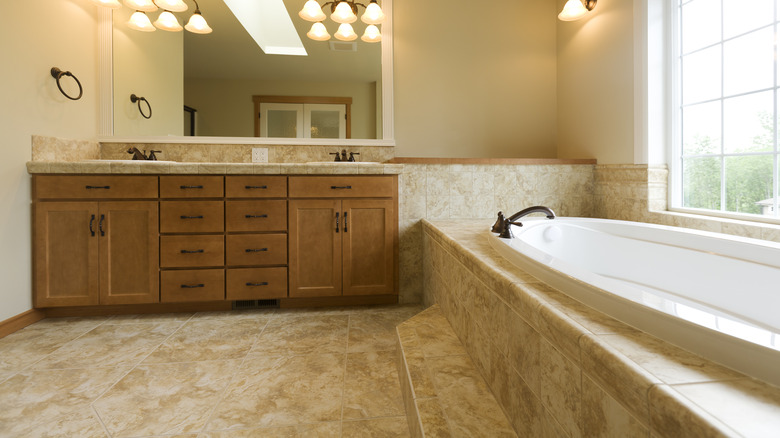 Bathroom with travertine floor and tub tile in shades of brown