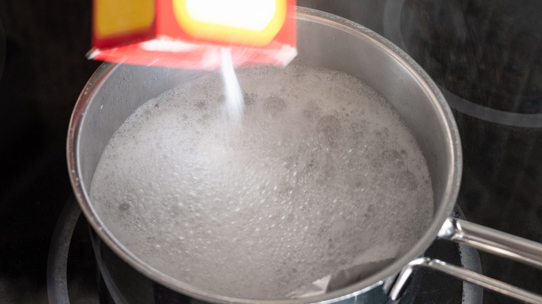 Pouring baking soda into pan
