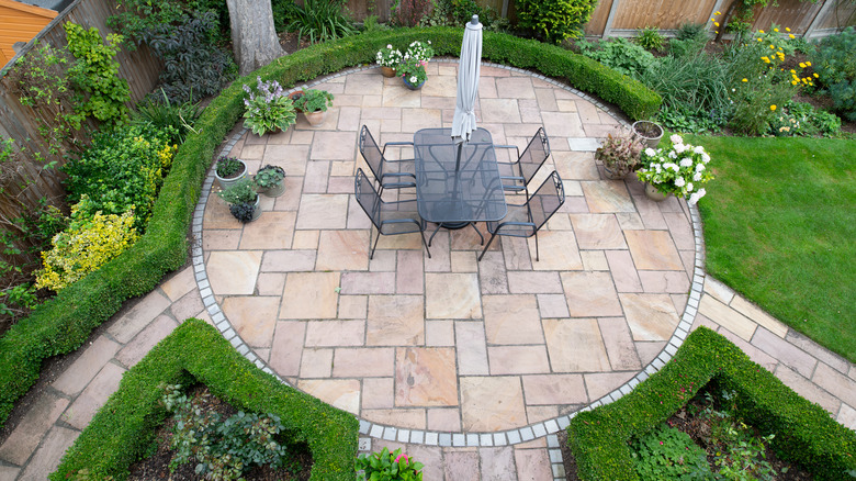 A circular patio surrounded by hedges