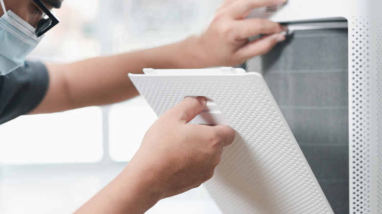 person removing air purifier filter