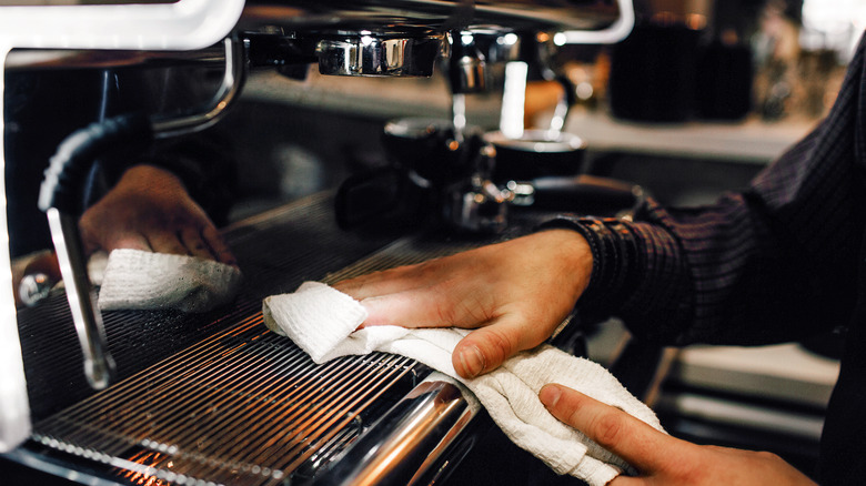 man's hands with towel cleaning coffee maker