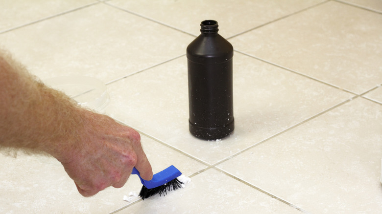 Person scrubbing tile grout