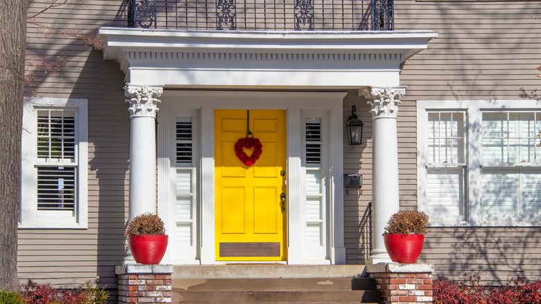 yellow door with red heart wreath 