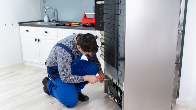 Technician repairing refrigerator