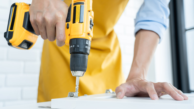 person drilling into screw