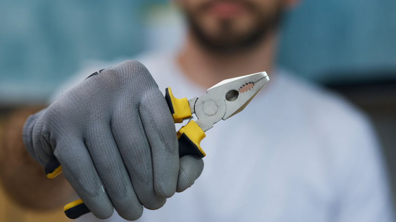 Man holding yellow pliers