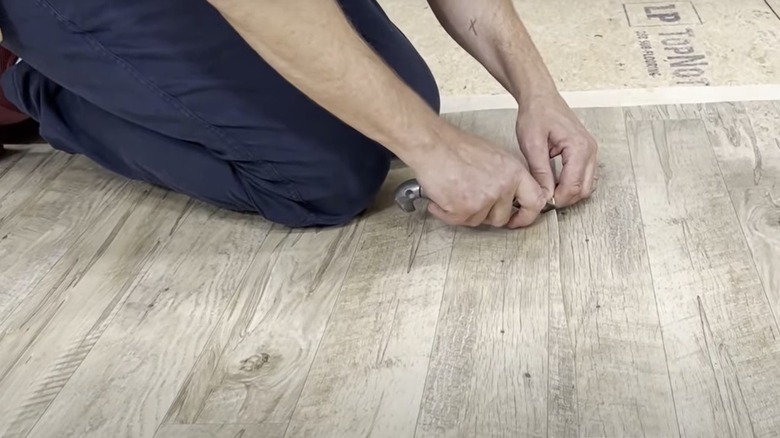 Person fixing seam in vinyl floor