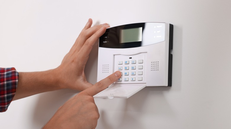 hands adjust security panel