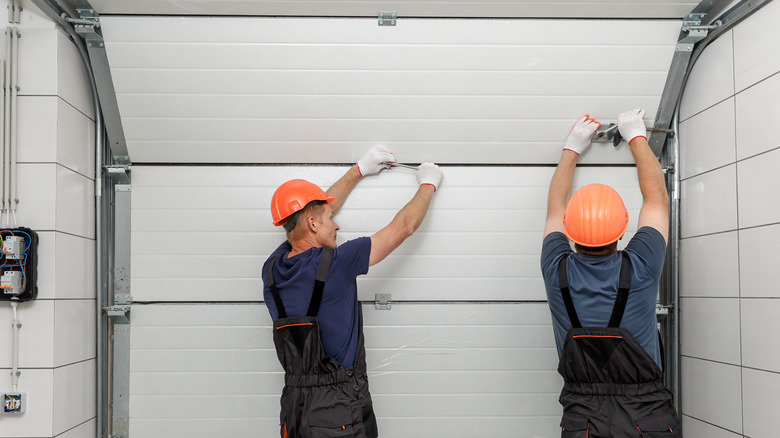 People fixing garage door